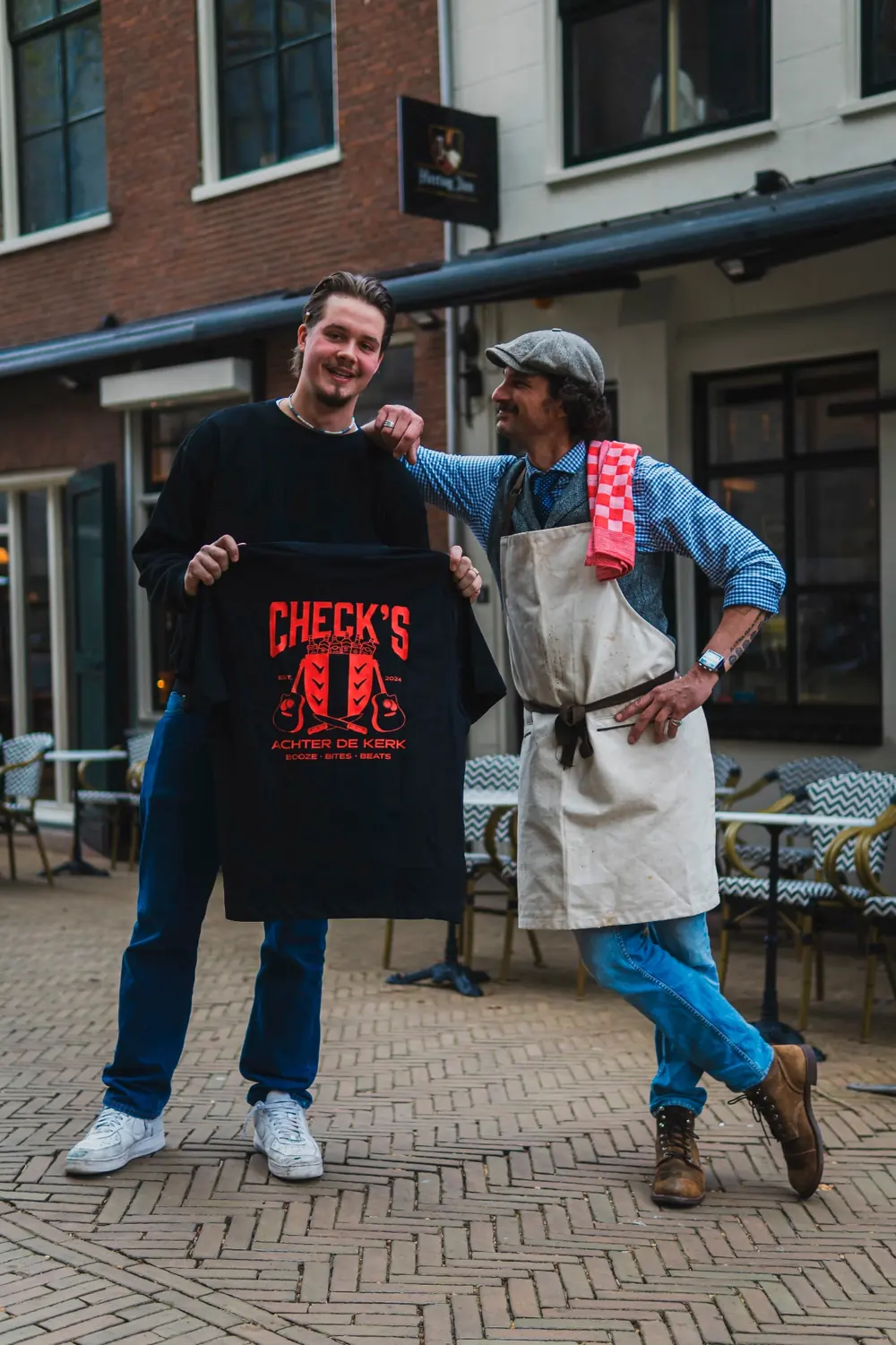 Pieter en Lucas met het zwarte Check's Achter de Kerk shirt met rode letters voor de bar